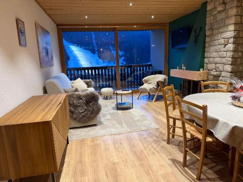 a living room filled with furniture and a large window at Morz'Inn Vue panoramique sur les montagnes in Morzine