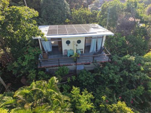 a house with a solar roof in the trees at Pousada VillaBahia Morro in Morro de São Paulo