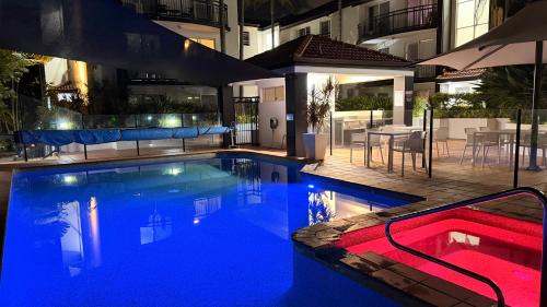 a large swimming pool with a red hot tub in a building at Santana Resort Surfers Paradise in Gold Coast