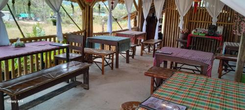 a group of tables and chairs in a restaurant at Khao Sok Moon Light Hill Camp in Khao Sok National Park