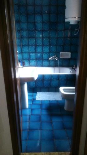 a blue bathroom with a tub and a toilet at Blue Dandelion in Paliouri