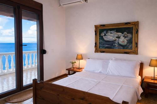 a bedroom with a bed with a view of the ocean at Blue Dandelion in Paliouri