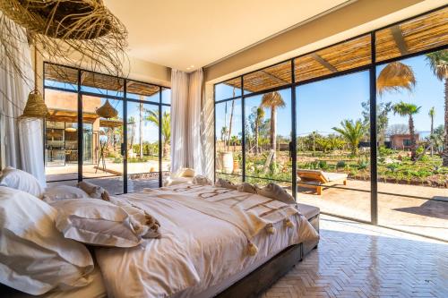 a bedroom with a large bed and large windows at VILLA 2s in Marrakesh