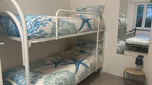 a bunk bed with blue and white bunk beds in a room at Casa Conchiglia 6 ospiti 5 minuti a piedi da mare, centro e stazione comfort completo in Rapallo