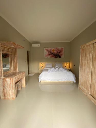 a large bedroom with a bed and a table at the gosana in Amed