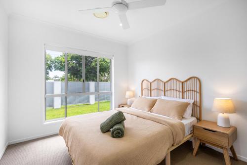 a bedroom with a large bed and a window at Mooloolaba Parkway Palms Spacious 3BR with Patio & BBQ Pet-Friendly near the Beach in Mooloolaba