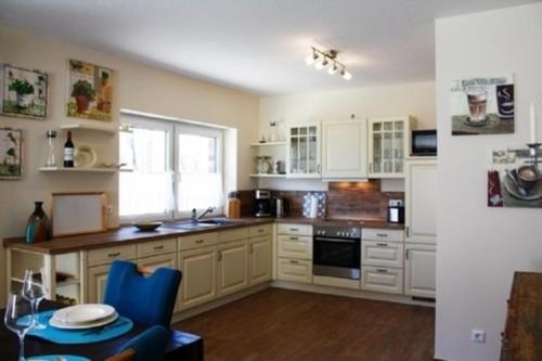 a kitchen with white cabinets and a blue chair at Peter in Lenz
