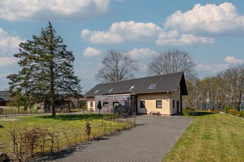 a white house with a black roof at Aga Seeromantik Ben in Lenz