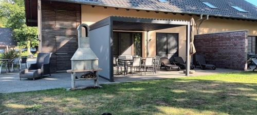 a patio with a grill and chairs and a house at Aga Seeromantik Ben in Lenz