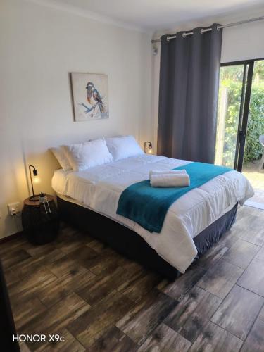 a bedroom with a large bed with a wooden floor at Urban Nest Self Catering in George