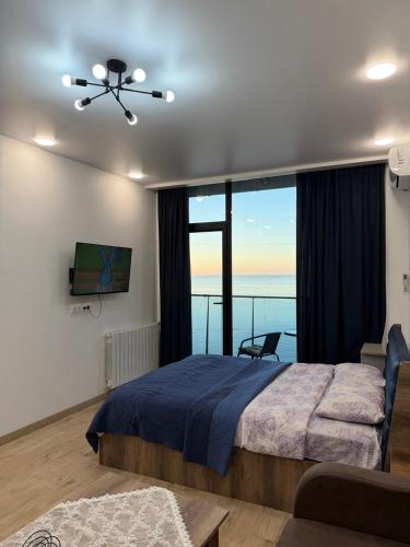 a bedroom with a bed and a large window at NBG Aparthotel in Batumi