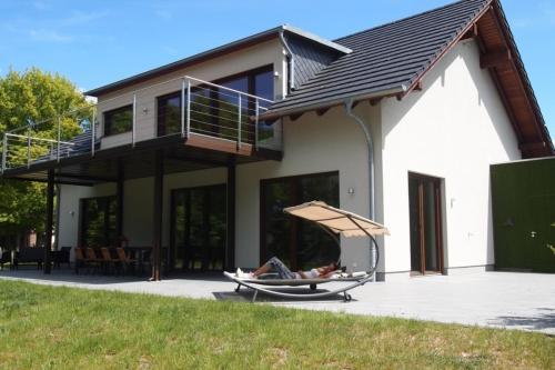 a person laying in a hammock in front of a house at Seehaus in Lenz