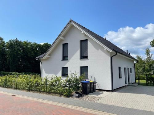 a white house with a fence in front of it at Seemöwe in Lenz