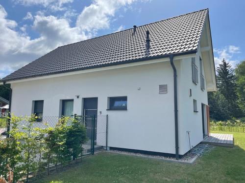 a white house with a black roof at Seemöwe in Lenz