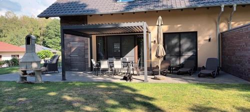 a patio with chairs and umbrellas next to a house at Ben in Lenz