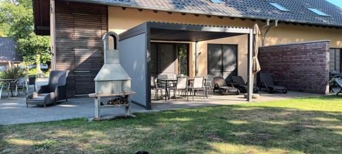 a house with a patio with a fireplace in the yard at Ben in Lenz
