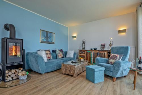 a living room with two blue couches and a fireplace at Lago EG in Lenz