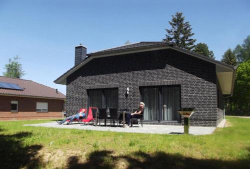 a woman sitting on a porch of a brick house at Valentina in Lenz