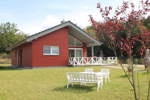 a red house with a bench in front of it at Trine in Lenz