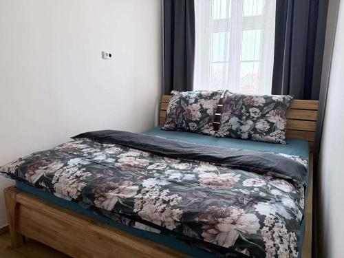 a bed with a floral comforter and two pillows at Parkány Litoměřice in Litoměřice