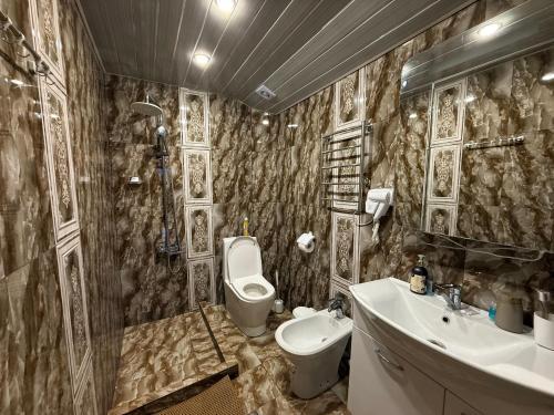 a bathroom with a toilet and a sink and a toilet istg at Sunny Village Hotel in Haghpat
