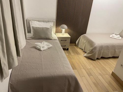 een slaapkamer met twee bedden en een tafel met een lamp bij Rooms Marija in Split