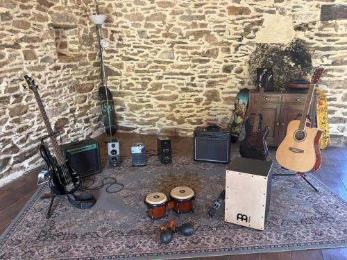 a room with a bunch of guitars and other musical instruments at Aux 12 instants, Imagine in Lédergues