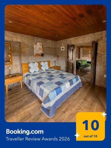 a bedroom with a bed with a blue and white comforter at Casa do Cabeço de Boi by Refúgio ao Luar in Terras de Bouro