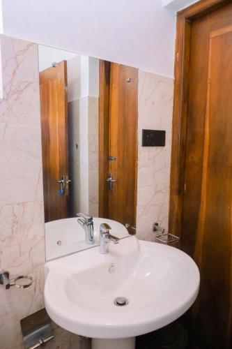 a bathroom with a white sink and a mirror at Ru Hotel & Villa in Nuwara Eliya