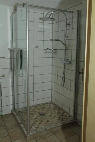 a bathroom with a shower with a glass door at Pension Schiffer in Blankenheim