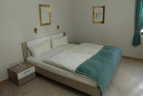 a bedroom with a bed and a night stand at Pension Schiffer in Blankenheim