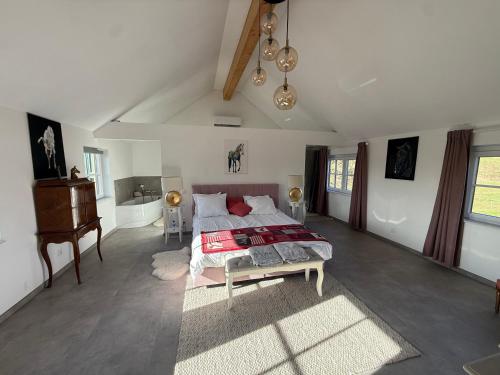 a bedroom with a bed and a table and a piano at Horse Lodge de Bélian in Hannut
