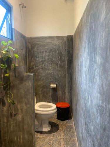 a bathroom with a toilet and a plant in it at Bamboo Garden Inn in Goiyapana