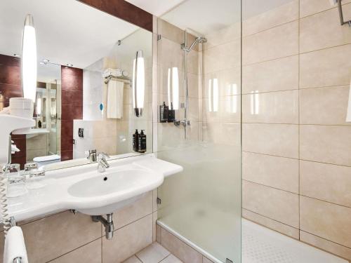 a white bathroom with a sink and a shower at Mercure Karpacz Skalny in Karpacz