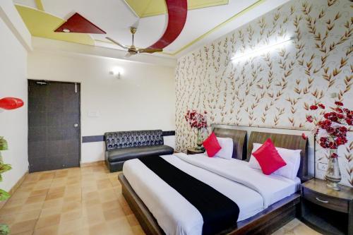 a bedroom with a large bed with red pillows at Hotel O Mukut Mahal in Meerut