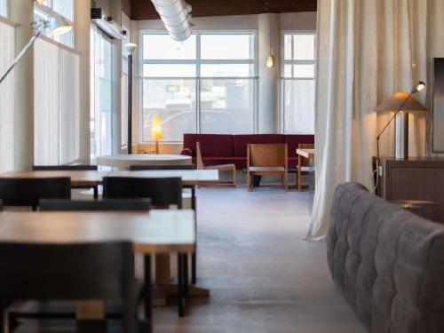 a large room with tables and chairs and windows at Ibis Valencia Alfafar in Alfafar
