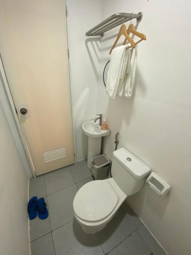 a white bathroom with a toilet and a sink at L & Ev Be My Guest in San Juan