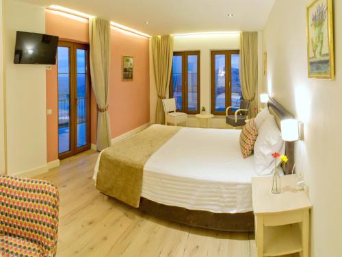 a hotel room with a large bed and windows at Arktos Hotel in Ioannina