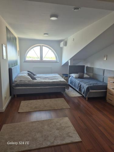 a bedroom with two beds and a window at Gościniec Chmielnicki in Chmielnik