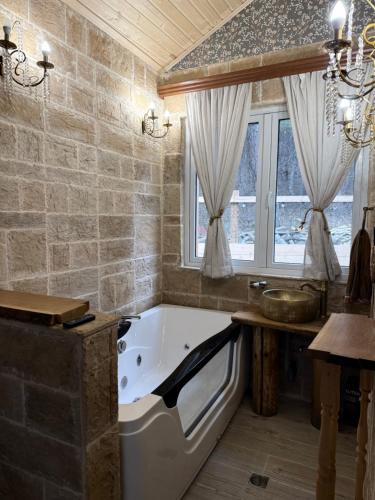 a large bathroom with a tub and a window at Birtvisi Dream House in Abrameti