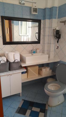 a bathroom with a sink and a toilet and a mirror at Little Paradise in Siviri in Siviri