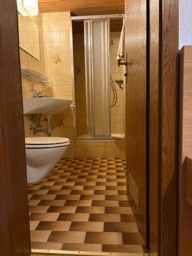 a bathroom with a toilet and a sink at Das Alpenglühn Hotel & Restaurant in Krün