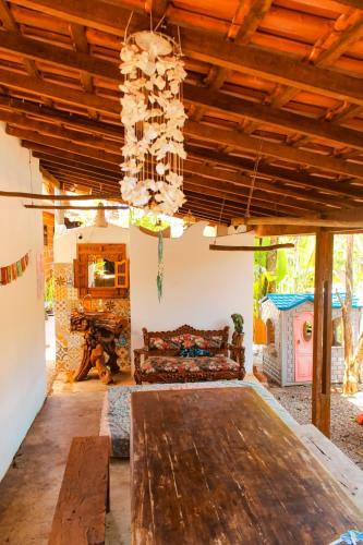 a living room with a large wooden table and a couch at Ganesh Chalés in Boracéia