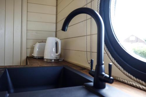 a kitchen sink with a faucet next to a window at Spring Tide Cliff Top Glamping Pod with direct Sea Views in Birchington