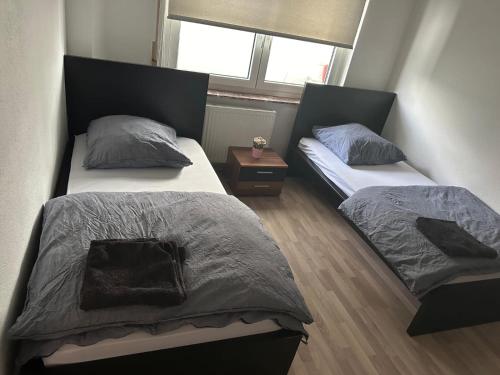a bedroom with two beds and a night stand at Frankfurt Airport & Fair Apartment in Kelsterbach