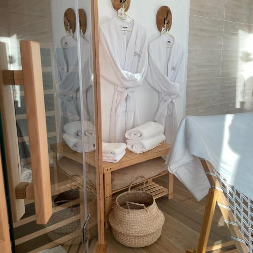 a dressing room with white robes and towels at O'Manava Lodge & Bien-Etre in Virac