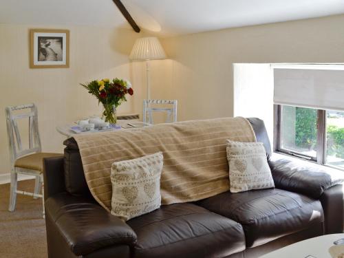 a living room with a couch with a blanket on it at Rosecraddoc Manor - Hayloft in Saint Cleer