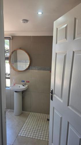 a bathroom with a sink and a mirror at Ntale Guest House in Benoni