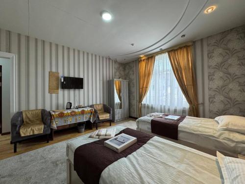 a hotel room with two beds and a couch at Узбечка in Tashkent
