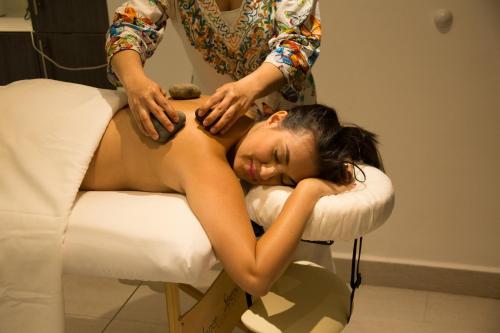 a woman getting a massage from a therapist at Hotel Medina Del Lago in Otavalo